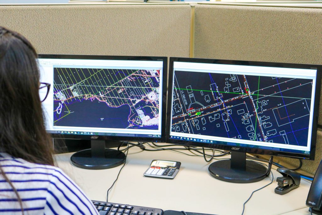 Informative Image of a multiVIEW CAD specialist taking utility engineering and geophysics data from a project site to create mapping records and reports.