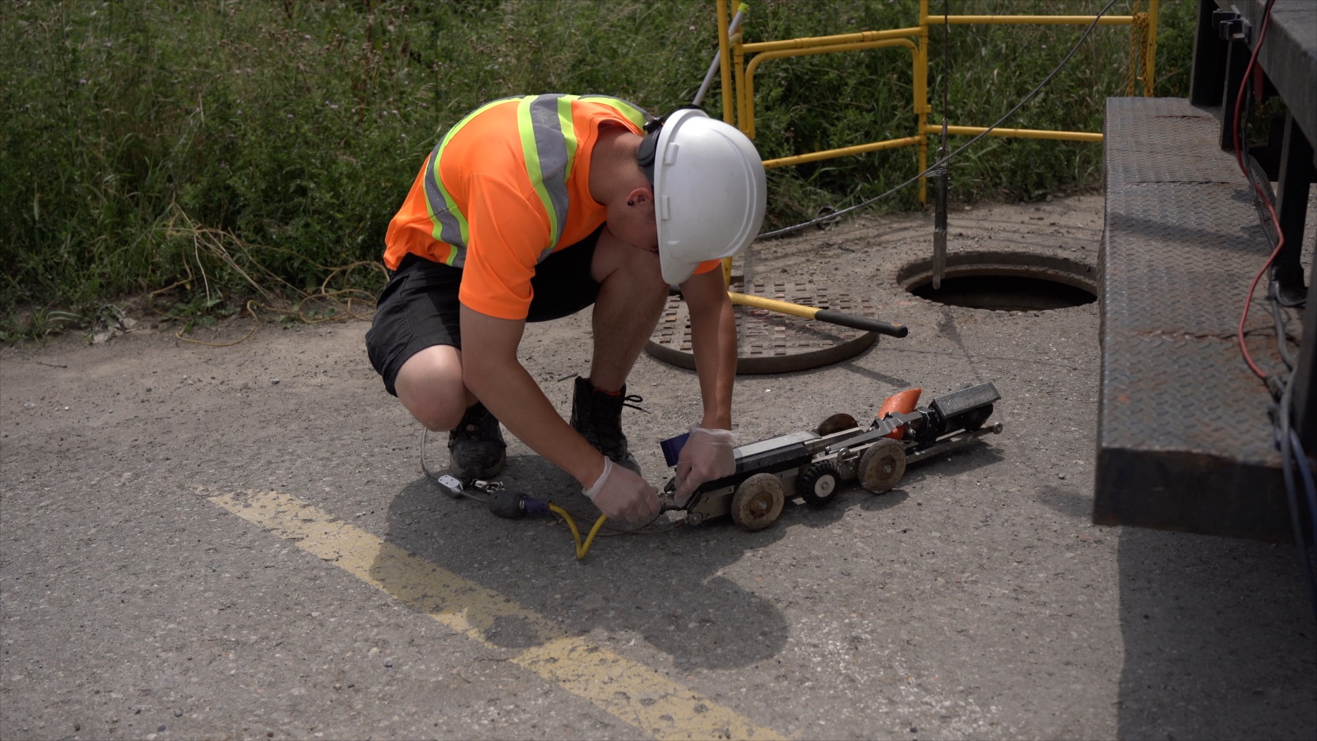 Photo of a multiVIEW technician connecting power cord to the robotic sewer camera in preparation for a CCTV inspection of a sewer pipeline condition assessment.
