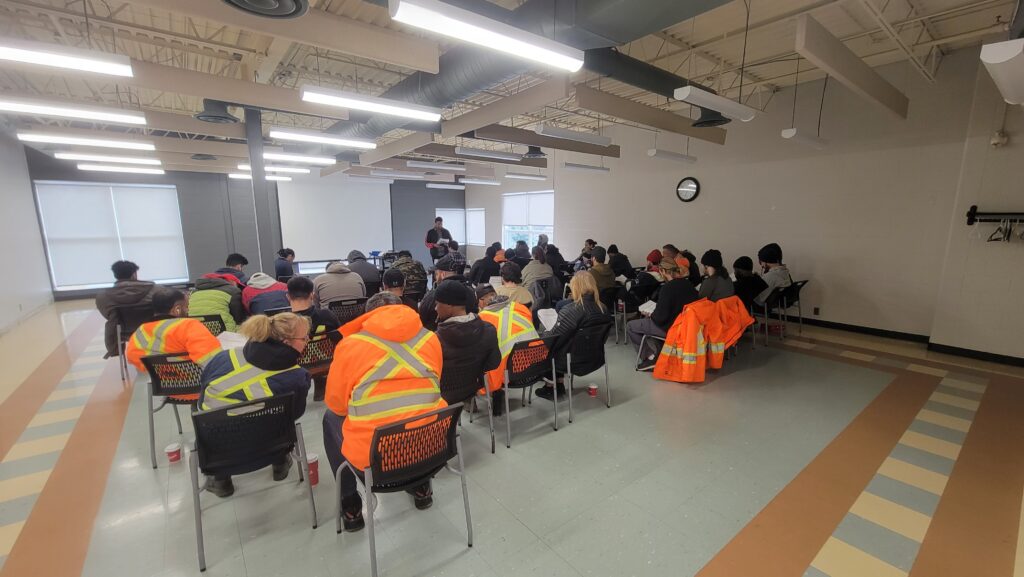 Photo displays a multiVIEW damage prevention training session in progress. The instructor can be seen delivering instructions to a room full of students on their route to becoming certified utility locators.